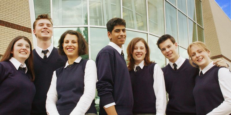 A group of Catholic school students holding hands in a circle, symbolizing unity, faith, and respect